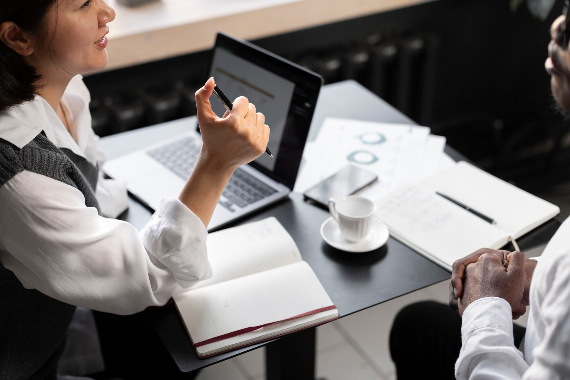 Business professionals working on laptop with coffee